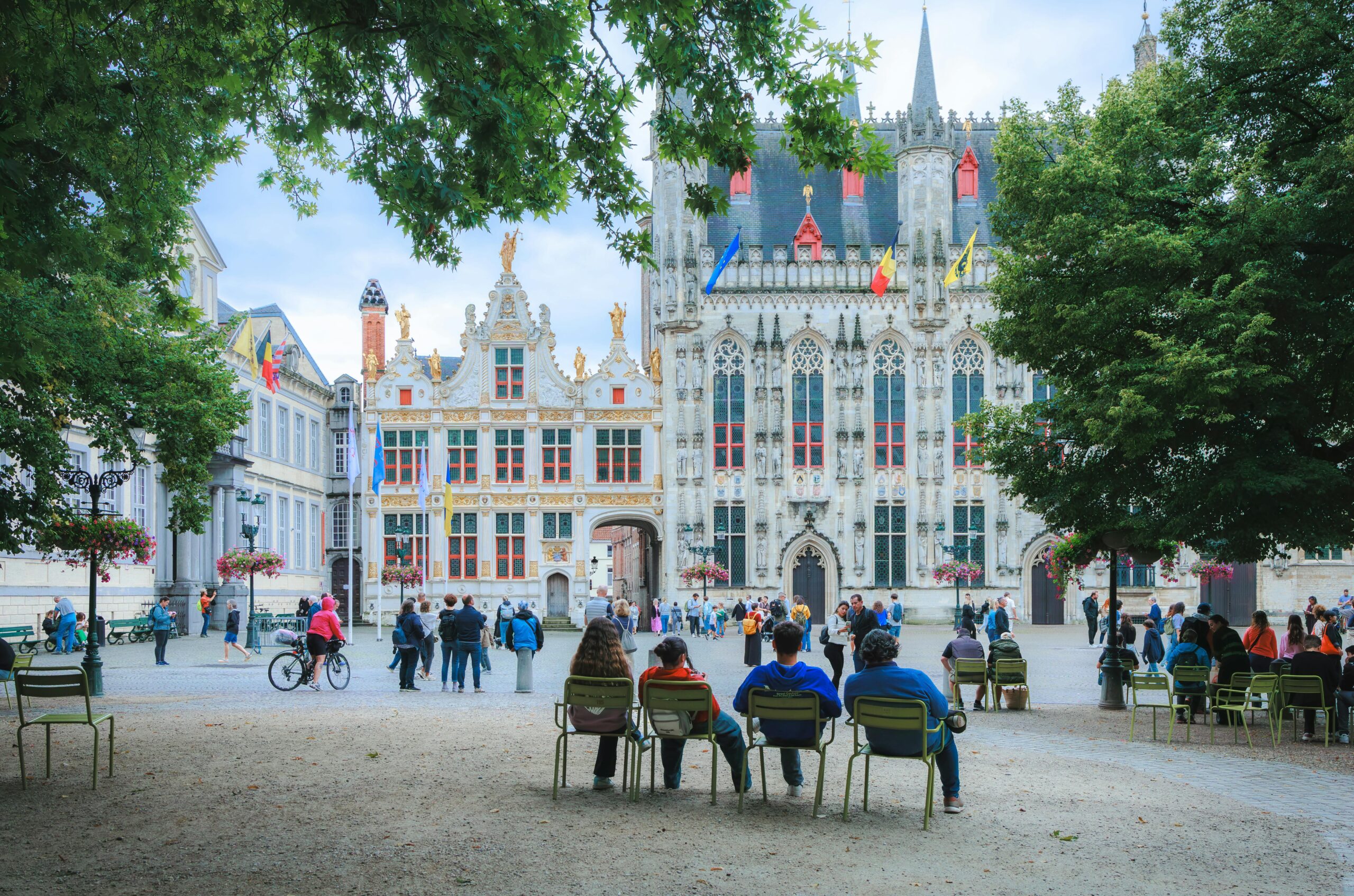 Menschen genieÃŸen einen Sommertag im Rathaus von BrÃ¼gge und bewundern die wunderschÃ¶ne flÃ¤mische Architektur.